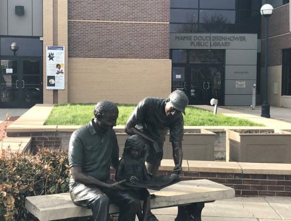 Statue of people reading in front of the Mamie Dowd Eisenhower Library entrance, Brommfield Colorado.